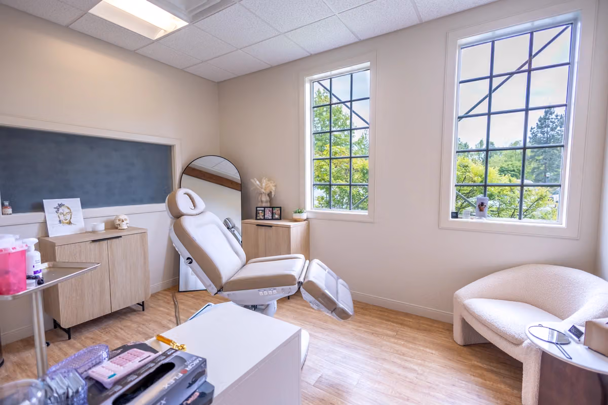 A treatment room with a reclining examination chair and large windows